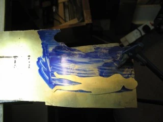 Adam partly cut out of brass sheet, with Eve beside