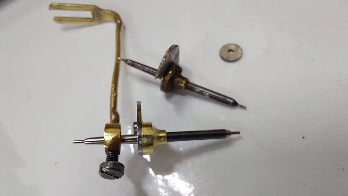 Two steel arbors and a brass crutch, out of a movement